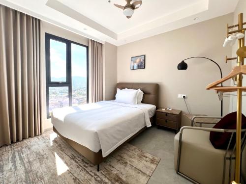 a hotel room with a bed and a chair at Landison Hotel Penang in George Town