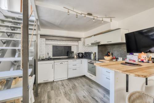 une cuisine avec des armoires blanches et un comptoir en bois dans l'établissement Maison de ville cosy Disney, à Chessy