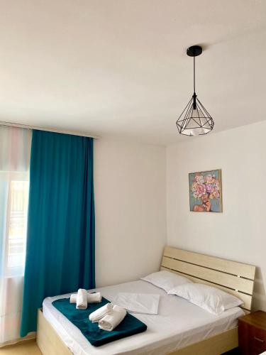 a bedroom with a bed with a blue curtain at Saint Gin Apartment in Shëngjin