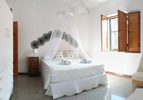a bedroom with a white bed with a mosquito net at Il nido in Marina di Massa