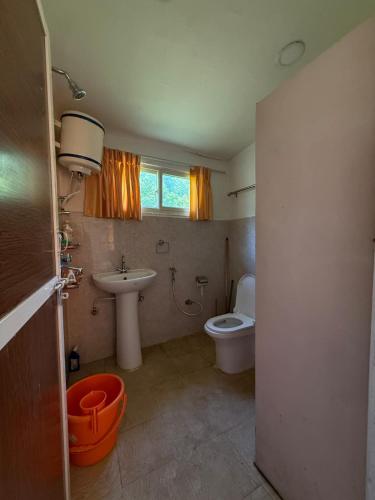 a bathroom with a toilet and a sink at Peaceful lakeview in Rānīpauwa