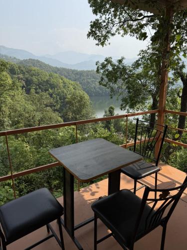 a table and two chairs on a balcony with a view at Peaceful lakeview in Rānīpauwa