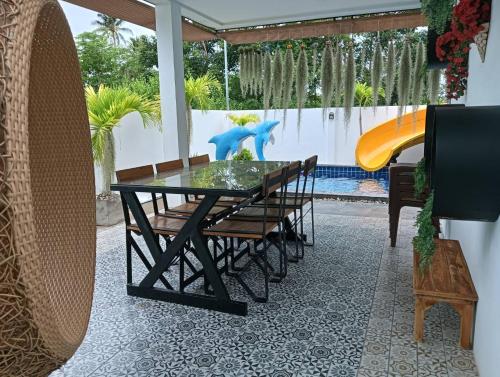a dining room with a glass table and a slide at Lemony Pool Villa - Hua Hin in Ban Thap Tai (1)