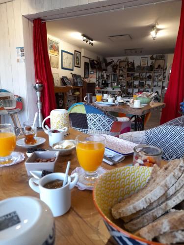 une table en bois surmontée d'assiettes et de tasses de jus d'orange dans l'établissement Maison Dougnac, à Fleurance