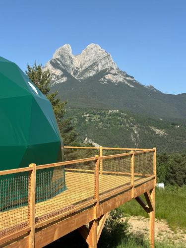 a wooden bridge with a mountain in the background at wecamp Pedraforca in Saldés
