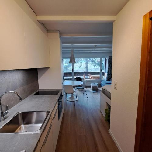 a kitchen with a sink and a table in a room at Le Flocon Studio in Ovronnaz close to the baths in Ovronnaz
