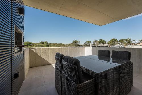 a patio with a table and chairs on a balcony at GuestReady - A charming place in a private condo in Apúlia