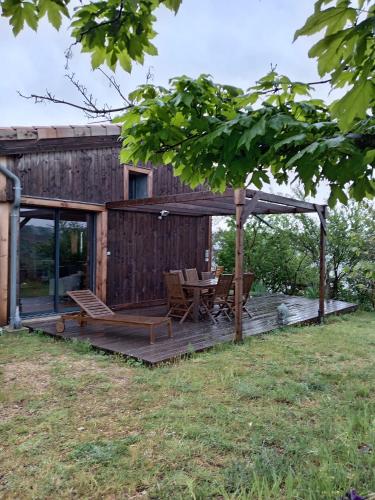 une terrasse en bois avec une table et des chaises dessus dans l'établissement Gîte vue sur le Rhône, à Sarras