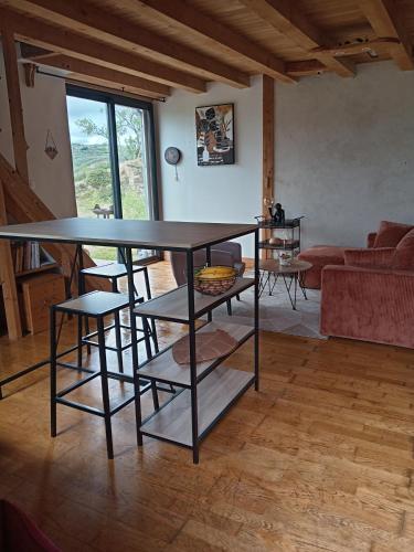 un salon avec une table, des chaises et un canapé dans l'établissement Gîte vue sur le Rhône, à Sarras