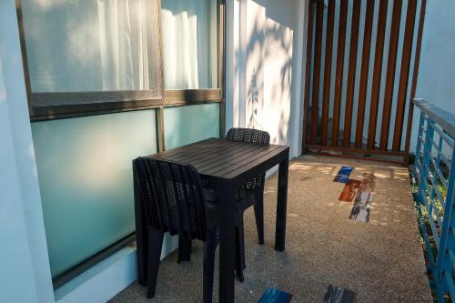 a small wooden table and chairs on a balcony at AV Suites in Puerto Galera