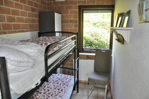 - une petite chambre avec des lits superposés et une fenêtre dans l'établissement Boerenslag 48, à Sint Maartensvlotbrug