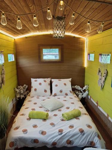 - un grand lit dans une chambre aux murs jaunes dans l'établissement Gîte vue sur le Rhône, à Sarras