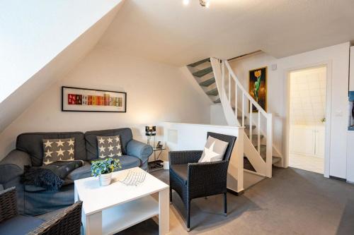 a living room with a couch and a staircase at Heefkant Haus Heefkant - App 7 in Rantum