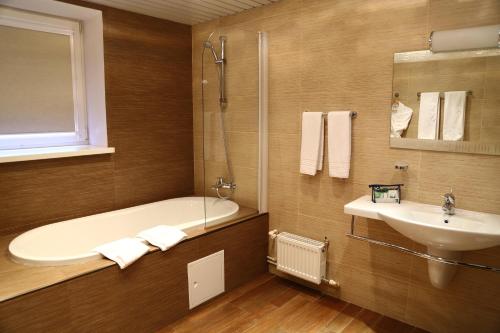 y baño con bañera y lavamanos. en Okhotnik Hotel, en Moscú