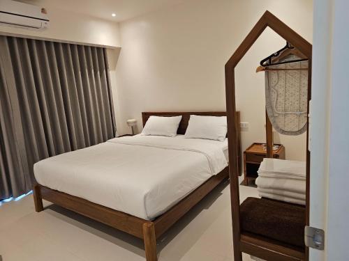 a bedroom with a bed with white sheets at Passara Villas in Ban Khlong Son