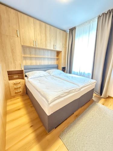 a bed in a bedroom with a large window at Riverside Apartment Praha in Prague