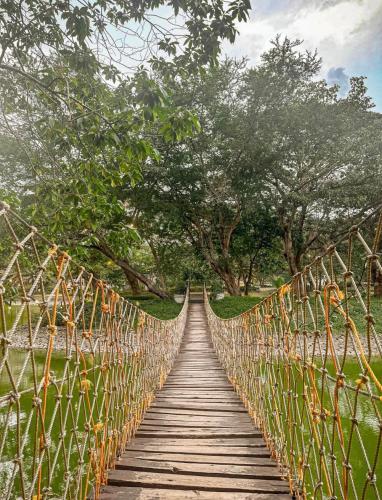a wooden suspension bridge with trees in the background at 1BR at Jacana B Pico de Loro in Nasugbu