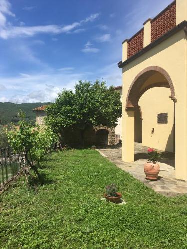 a yard with a building with an arch and plants at Da Vinci Sweet Home in Castiglion Fibocchi