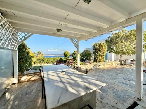 a patio with a table and a view of the ocean at Yaleena Residences in Drios