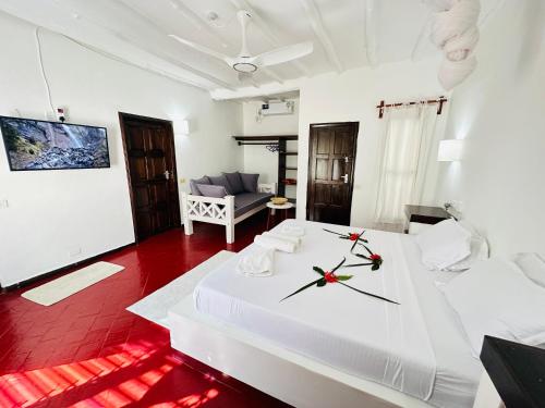 a bedroom with a large white bed with a clock on it at Studio Cecile in Malindi