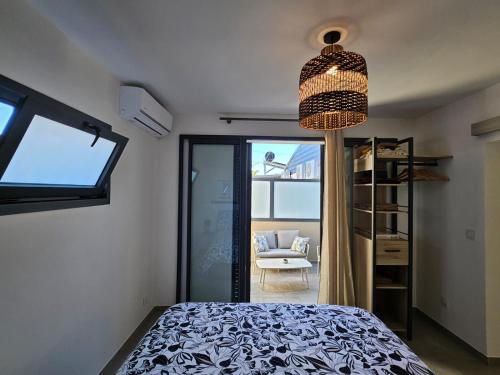a bedroom with a bed and a chandelier at joly brise in Saint-Pierre