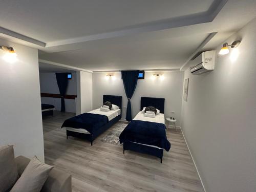 una habitación con dos camas y un sofá en Studio apartment Bulevar, en Mostar