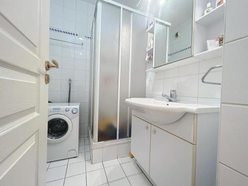La salle de bains blanche est pourvue d'un lavabo et d'un lave-linge. dans l'établissement Studio menton, à Menton