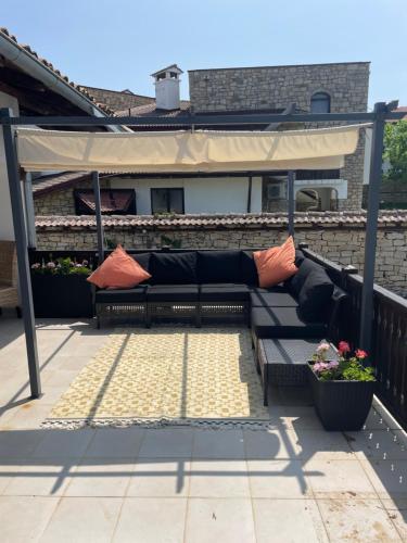 a patio with a couch under a canopy at Angliiska Vila in Arbanasi