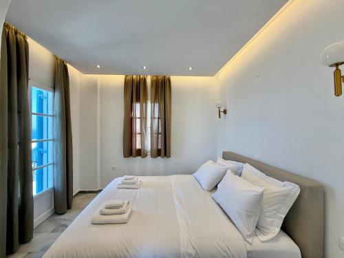 a bedroom with a large white bed with white pillows at Yaleena Residences in Drios