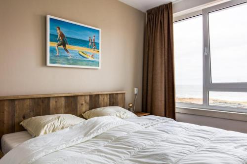 Un dormitorio con una cama y un cuadro en la pared. en Strand166, en Egmond aan Zee