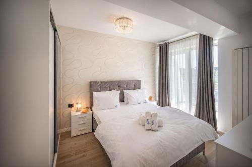 a bedroom with a white bed with two towels on it at Ricky Apartment in Infinity Spa & Pool in Mamaia Sat/Năvodari