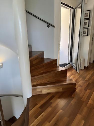 a staircase in a living room with wooden floors at Panoramic Holiday Villa in Montreux in Montreux