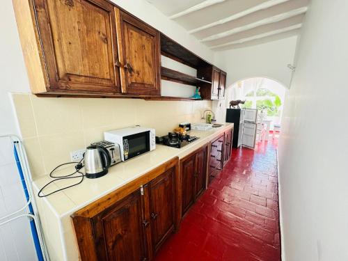 a kitchen with wooden cabinets and a microwave at Studio Cecile in Malindi