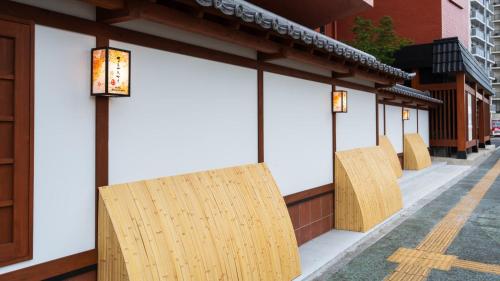 a row of wooden chairs on the side of a building at BeppuOnsen Hotel Sansenkaku in Beppu