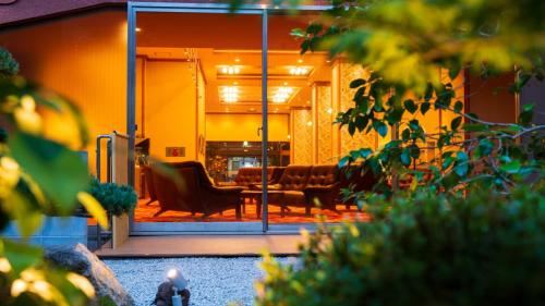 a living room with two chairs and a couch at BeppuOnsen Hotel Sansenkaku in Beppu