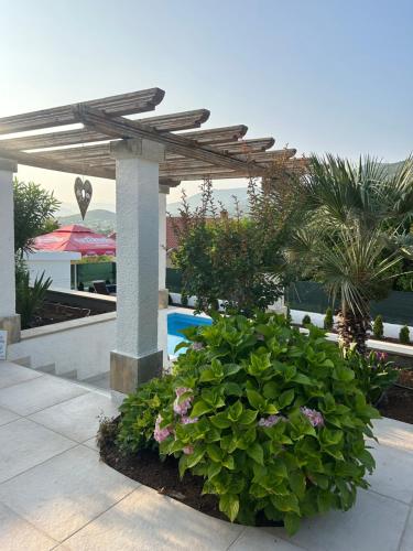 a garden with a wooden pergola and a pool at Riviera Blagaj in Blagaj