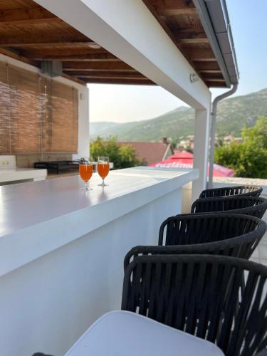 two glasses of orange juice sitting on a bar on a balcony at Riviera Blagaj in Blagaj