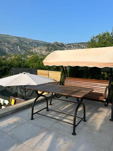 a picnic table and an umbrella on a patio at Riviera Blagaj in Blagaj