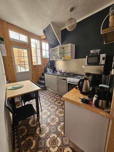 une cuisine avec une table et une cuisinière four supérieur dans l'établissement Nid nature et douceur à Eu - Proche du Treport et de la Baie de Somme, à Eu