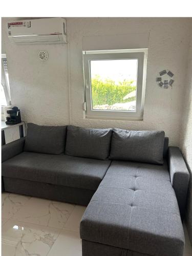 a living room with a couch and a window at Riviera Blagaj in Blagaj