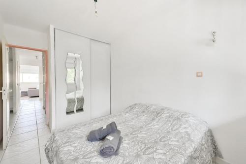 - une chambre blanche avec un lit et un grand miroir dans l'établissement T3 avec balcon proche de La Place Castellane, à Marseille