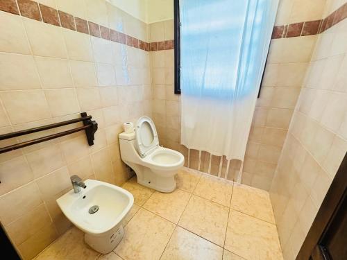 a bathroom with a toilet and a sink at Studio Cecile in Malindi