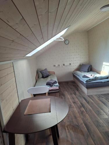 a room with two beds and a table in it at Lino butai number 1 in Kalviai