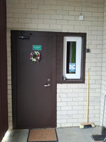 a brown door with a flower wreath on it at Lino butai number 1 in Kalviai
