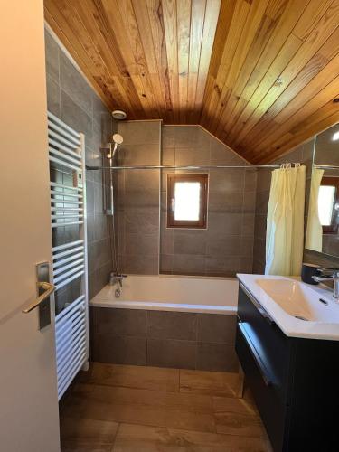 une salle de bain avec une baignoire et un lavabo dans l'établissement Le Petit Nid - Chalet Corrençon, à Corrençon-en-Vercors