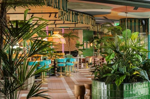 a restaurant with plants and tables and chairs at Quality Hotel The Reef in Frederikshavn