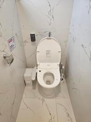 a bathroom with a toilet with a remote control at Hyupjae Hyun Stay in Jeju