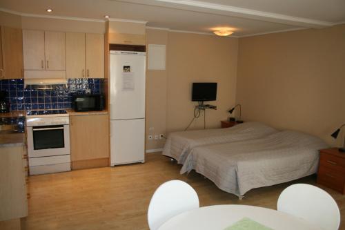 a small room with a bed and a kitchen at Visby Innerstad Lägenheter & Rum in Visby