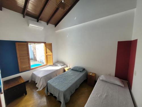 um quarto com duas camas e uma janela em Casa das Cores em Pirenópolis