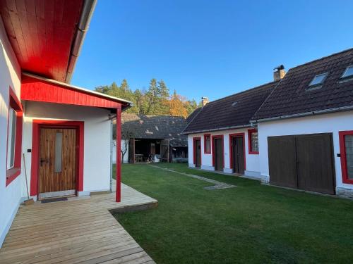 a backyard of a house with a wooden deck at Cosy Country House U Faflika with Sauna and 2 bathrooms in Vlkov